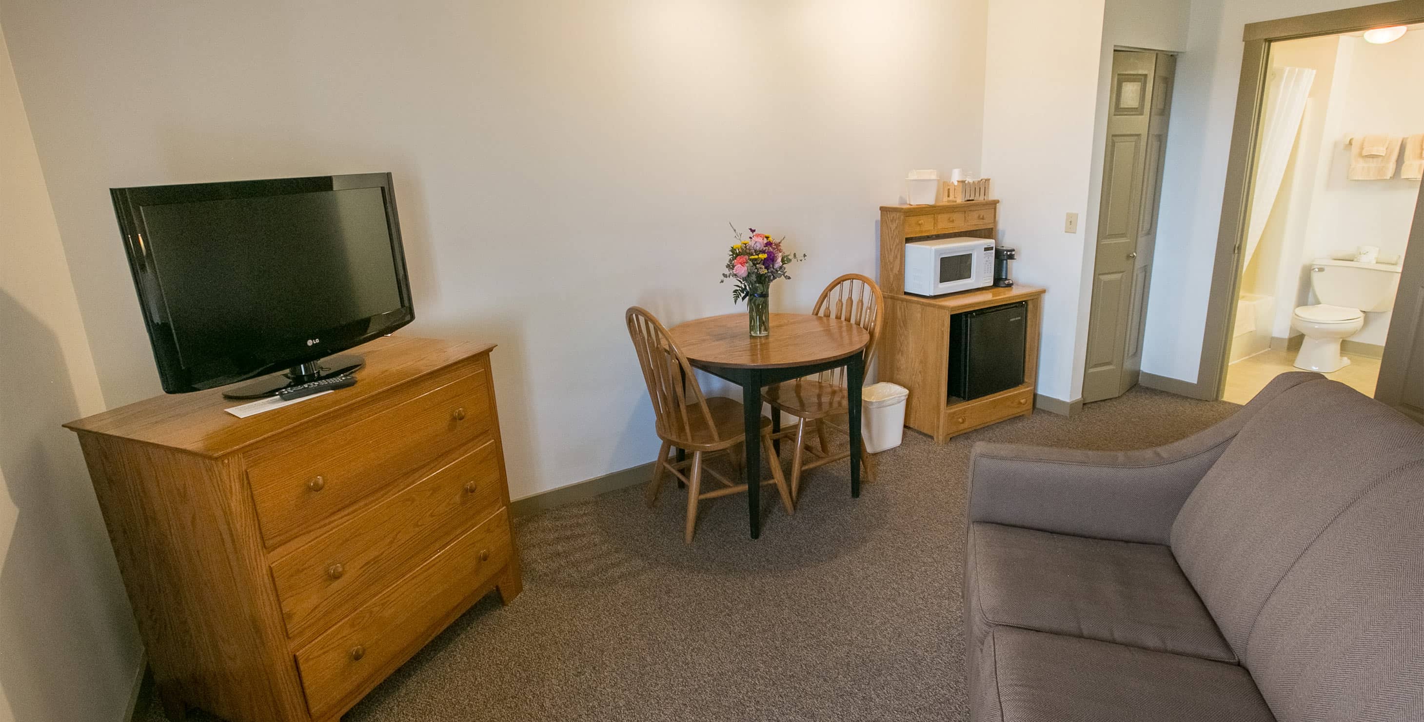 Couch, tv, microwave and fridge in King Suite